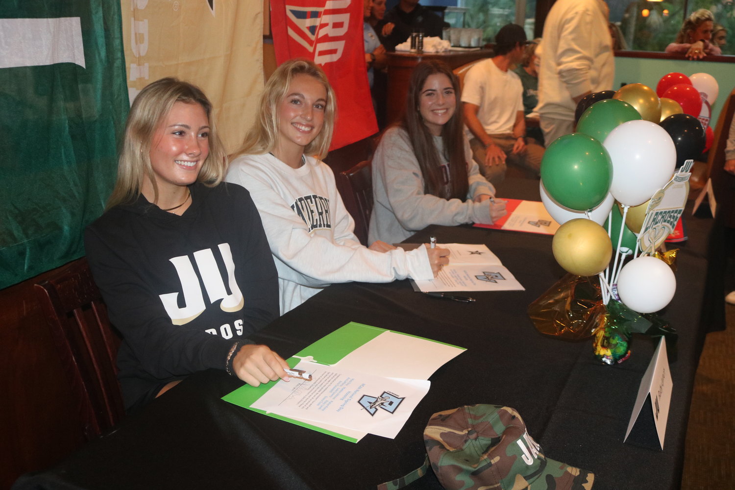 Ruby Lynch, Anna Taraboletti and Ava LaManna signed to play college lacrosse during a ceremony.